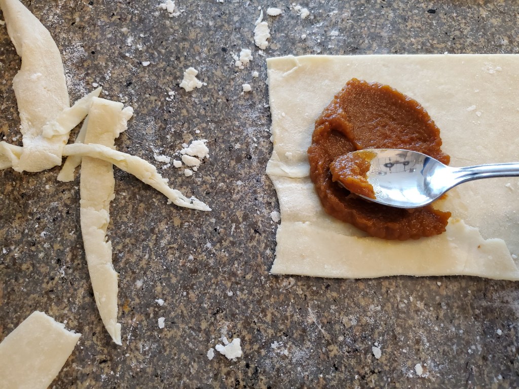 Spreading pumpkin mixture on dough