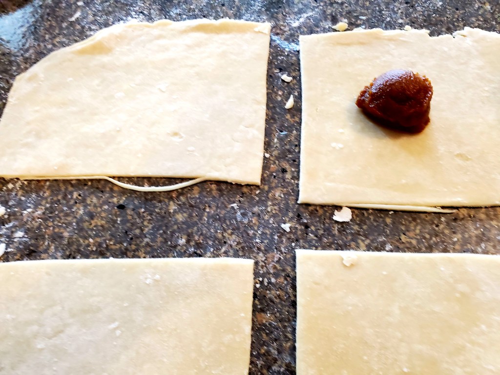 Dollop of pumpkin mixture on a piece of pie dough