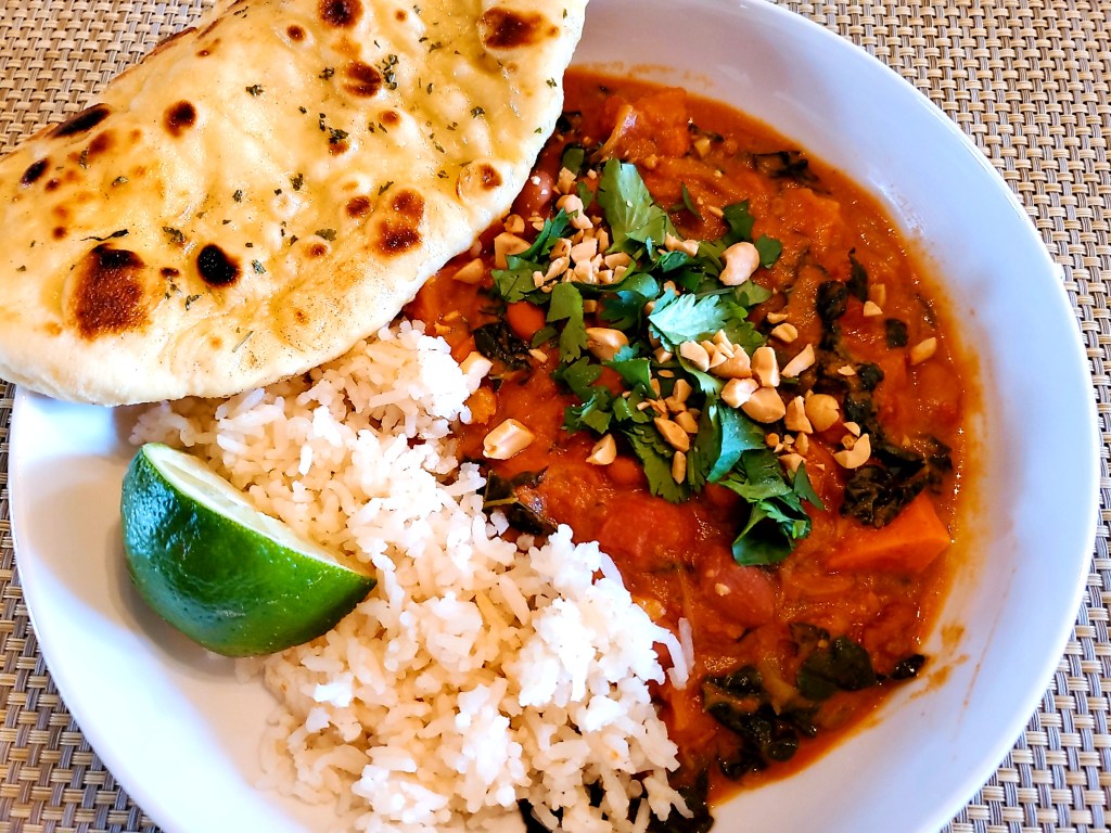 Plated African Peanut stew with rice and Naan bread